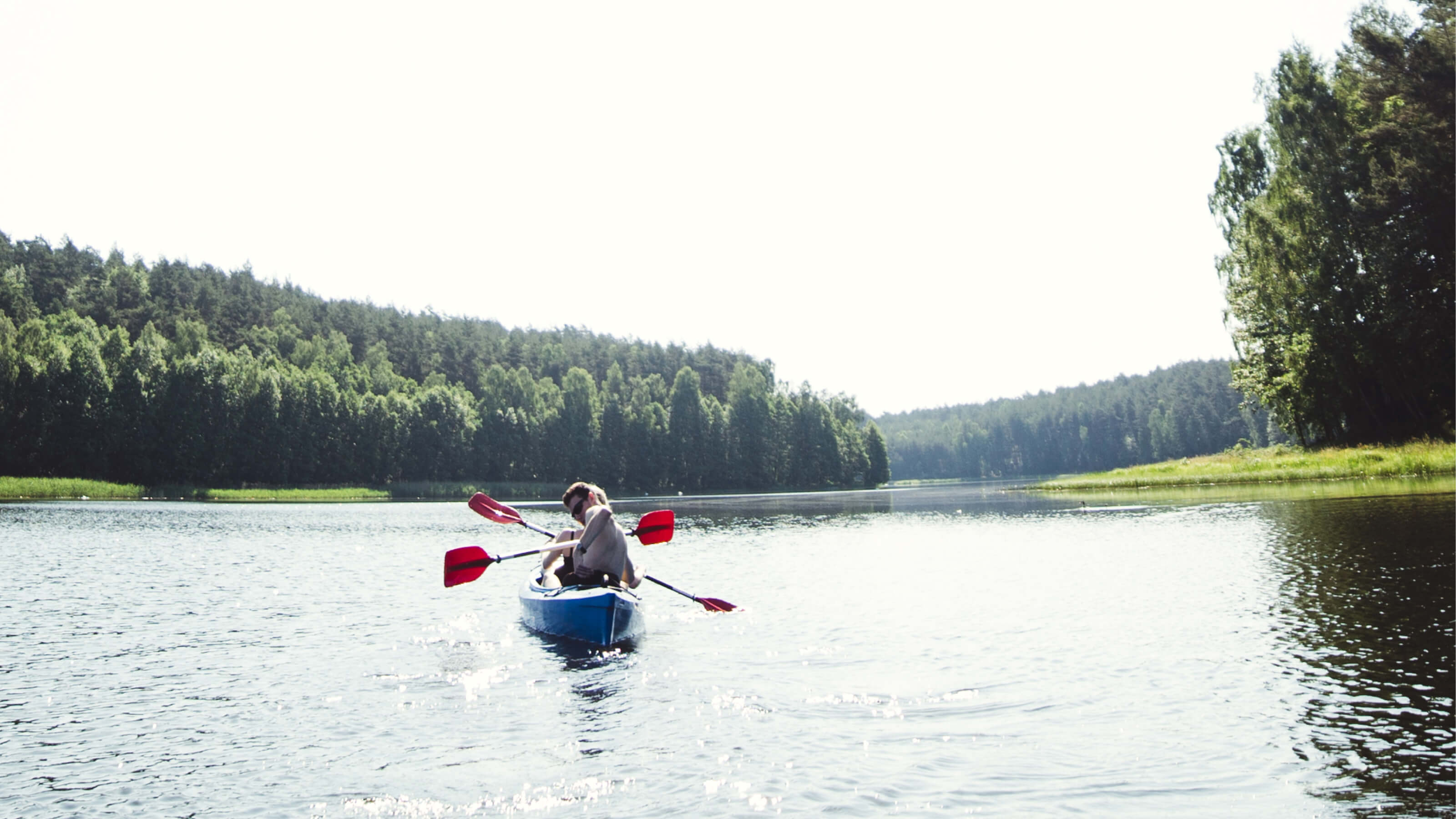Kajakarze w upalny dzień płynący przez jezioro Schodno.